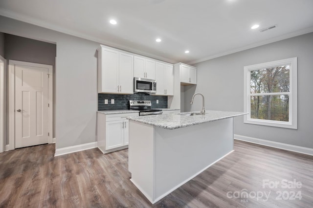 kitchen featuring appliances with stainless steel finishes, light wood-type flooring, sink, a center island with sink, and white cabinets