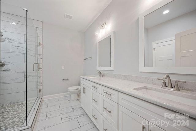 bathroom with vanity, toilet, and a shower with door