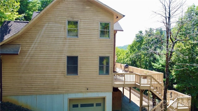 rear view of property with a garage and a deck