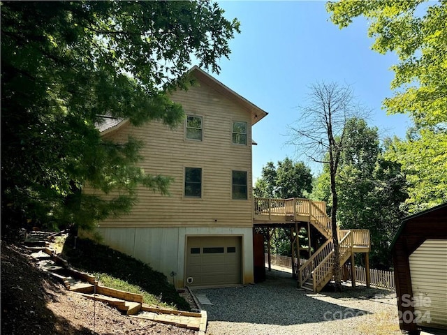 view of side of property featuring a garage and a wooden deck