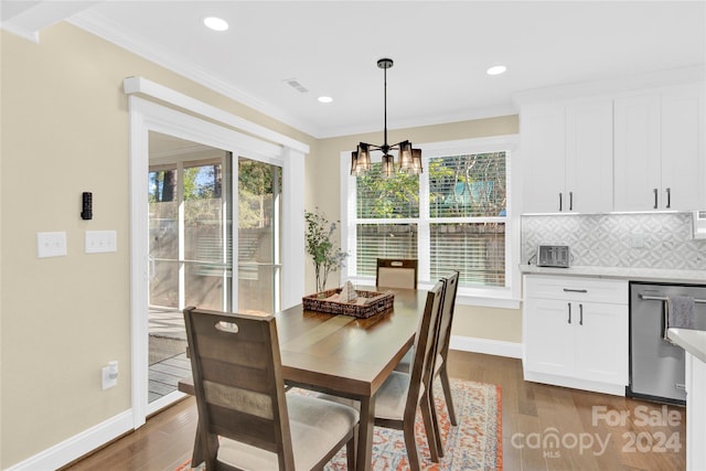 dining area with a notable chandelier, dark hardwood / wood-style flooring, and crown molding