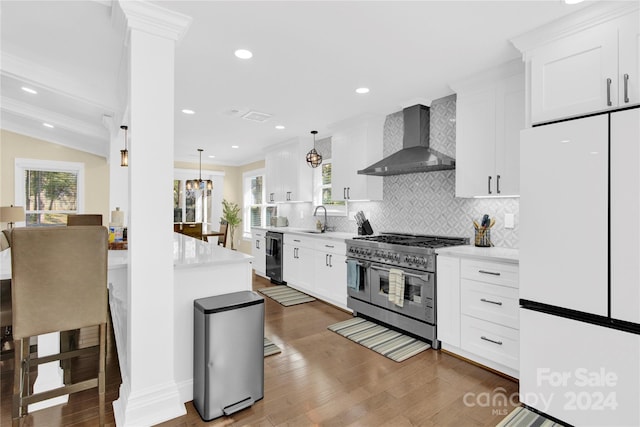 kitchen featuring double oven range, white cabinets, white refrigerator, sink, and wall chimney exhaust hood