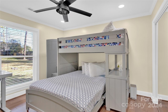 bedroom with ceiling fan, wood-type flooring, and ornamental molding