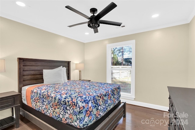 bedroom with dark hardwood / wood-style flooring, ceiling fan, and ornamental molding