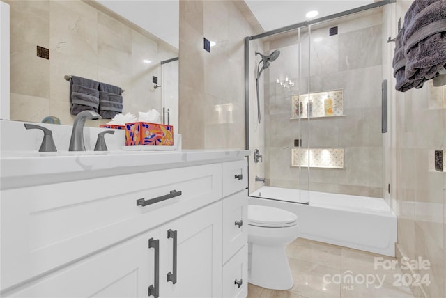 full bathroom with shower / bath combination with glass door, tile patterned floors, vanity, and toilet