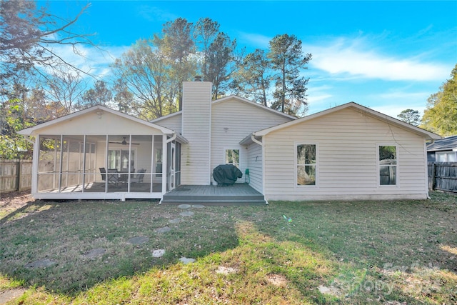 back of house with a lawn, a sunroom, and a wooden deck