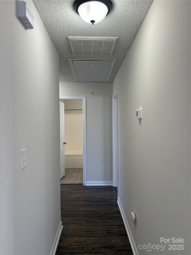 hallway featuring a textured ceiling and dark hardwood / wood-style floors