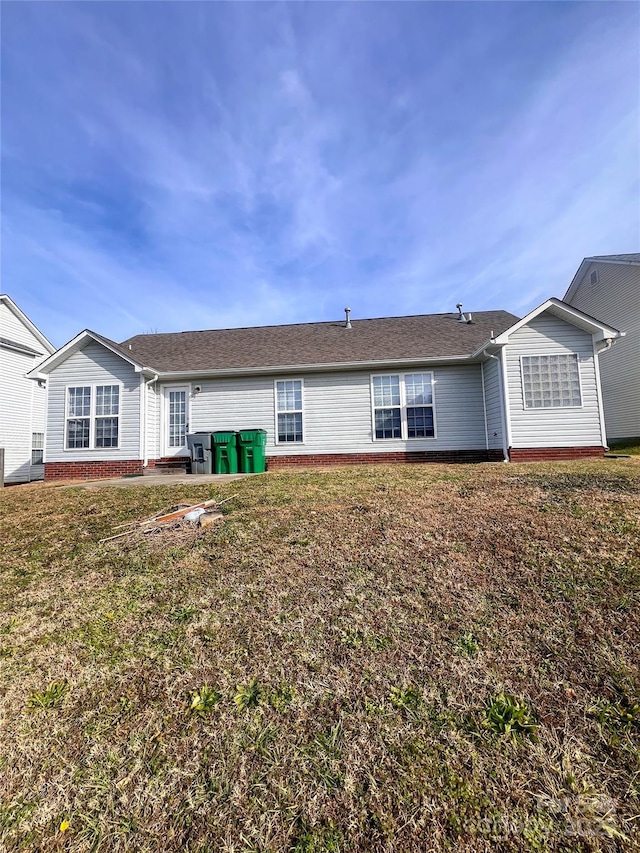 rear view of property with a lawn