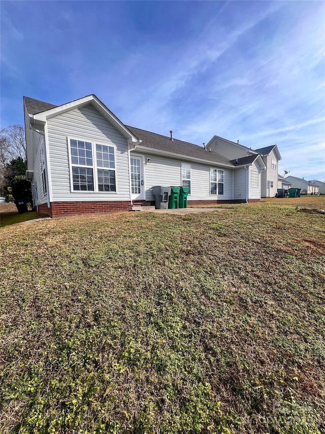 back of house with a lawn