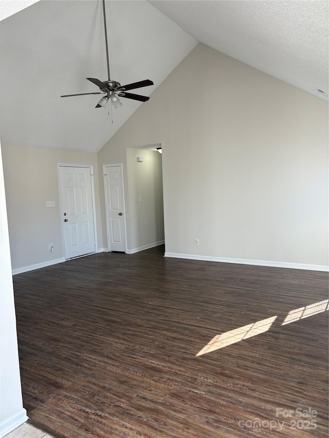 unfurnished living room featuring ceiling fan, dark wood-type flooring, and high vaulted ceiling