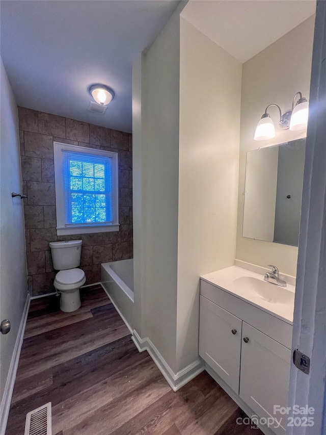 full bathroom featuring visible vents, toilet, wood finished floors, and vanity