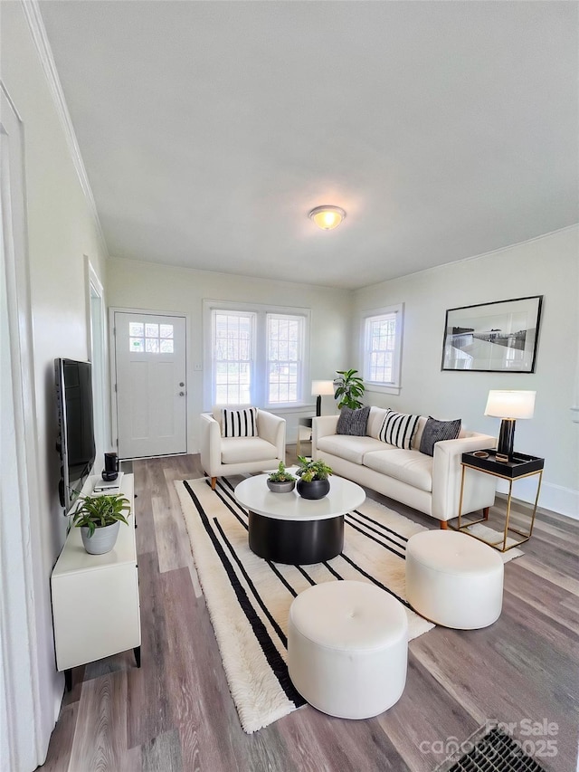 living room with crown molding, wood finished floors, and baseboards