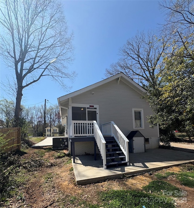 back of property with stairway, a patio, and fence
