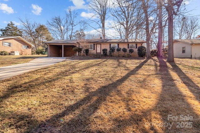 single story home featuring driveway, a front yard, and brick siding