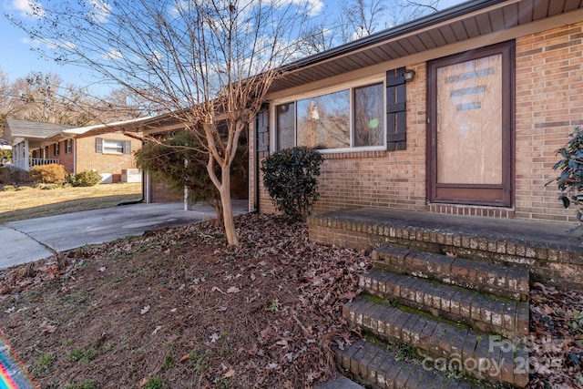 exterior space featuring driveway and brick siding