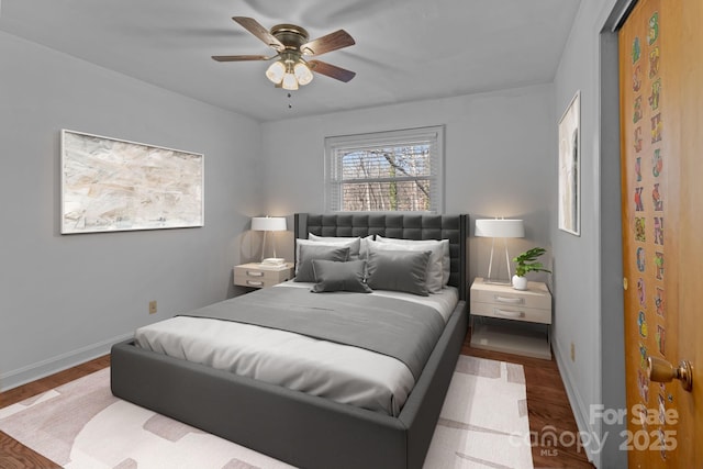 bedroom featuring a ceiling fan, baseboards, and wood finished floors