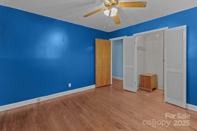 unfurnished bedroom featuring a ceiling fan, baseboards, and wood finished floors