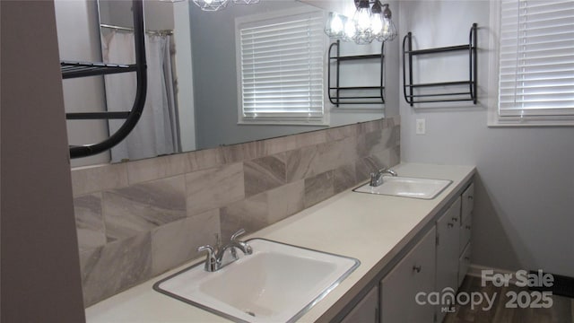 bathroom with double vanity, backsplash, and a sink