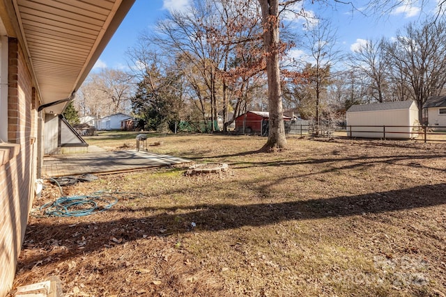 view of yard featuring an outbuilding and fence