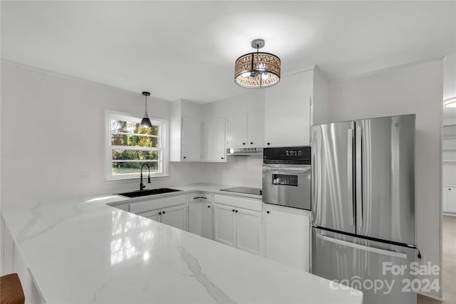 kitchen featuring white cabinets, sink, light stone countertops, appliances with stainless steel finishes, and decorative light fixtures