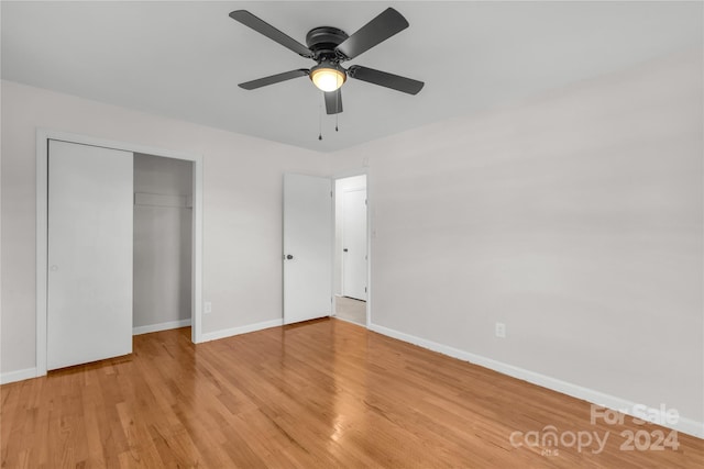 unfurnished bedroom featuring ceiling fan, a closet, and light hardwood / wood-style flooring