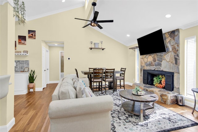 living room featuring a fireplace, crown molding, and light hardwood / wood-style flooring