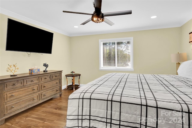 bedroom featuring light hardwood / wood-style flooring, ceiling fan, and ornamental molding