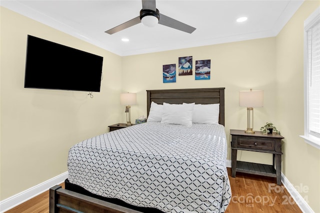 bedroom with ceiling fan, ornamental molding, and hardwood / wood-style flooring