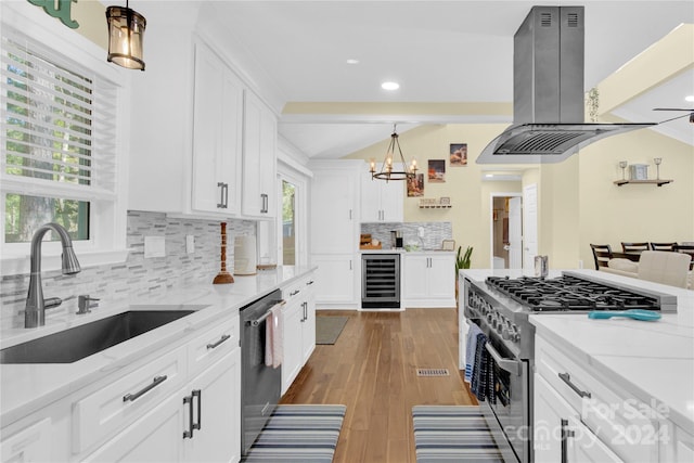 kitchen with white cabinetry, island range hood, hardwood / wood-style floors, and stainless steel appliances