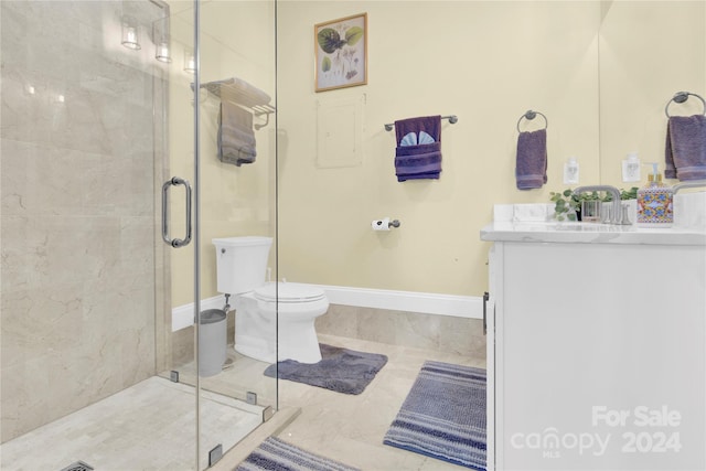 bathroom featuring tile patterned flooring, vanity, toilet, and walk in shower