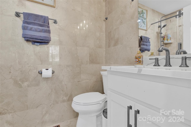 bathroom with vanity, tile walls, and toilet