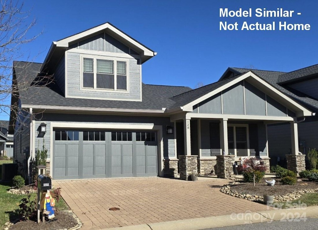 craftsman-style home with central AC unit, a garage, and covered porch