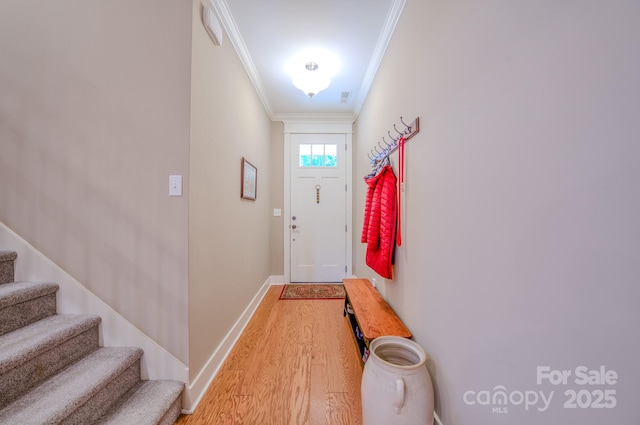 doorway featuring ornamental molding and light hardwood / wood-style floors