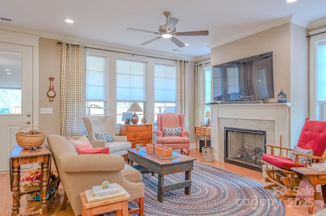 living room with ornamental molding, hardwood / wood-style flooring, and a tile fireplace