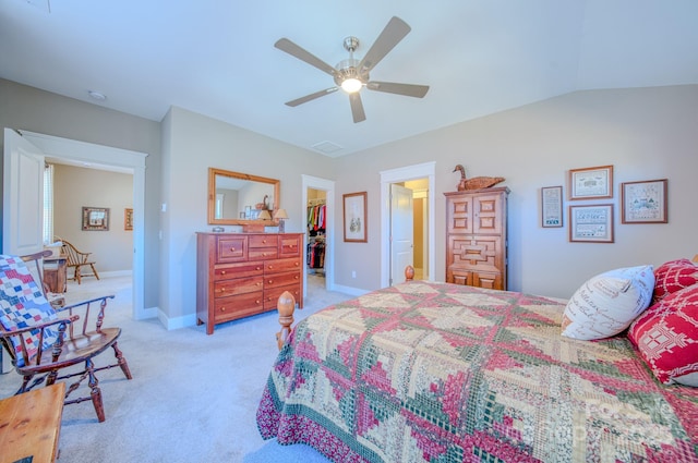 bedroom featuring a spacious closet, light carpet, ceiling fan, a closet, and vaulted ceiling