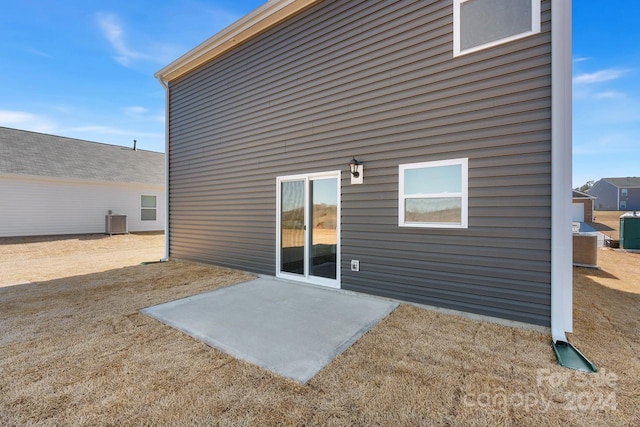 rear view of house featuring a patio area and central AC