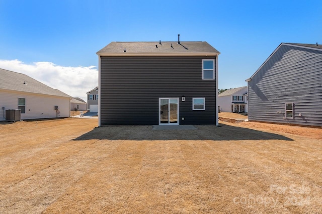 rear view of property featuring a lawn and central AC