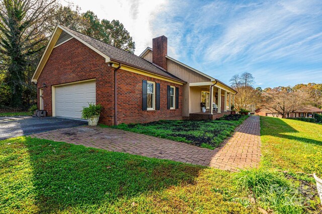 view of home's exterior featuring a yard, a porch, and a garage