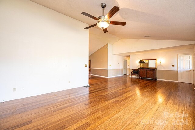 unfurnished living room featuring a textured ceiling, ceiling fan, wood-type flooring, and lofted ceiling