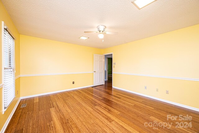 spare room featuring ceiling fan, hardwood / wood-style floors, and a textured ceiling