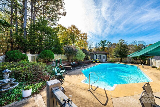 view of pool featuring an outbuilding and a patio area