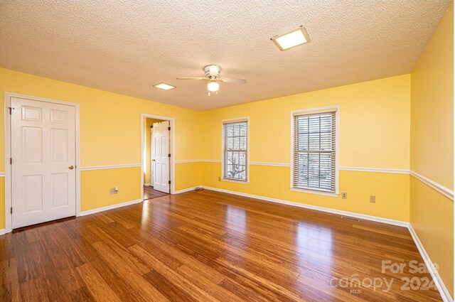 unfurnished room featuring ceiling fan, hardwood / wood-style floors, and a textured ceiling