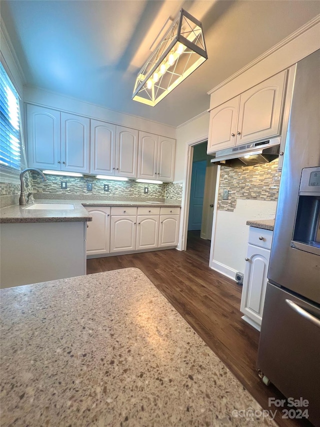 kitchen with sink, stainless steel refrigerator with ice dispenser, dark hardwood / wood-style floors, decorative backsplash, and white cabinetry