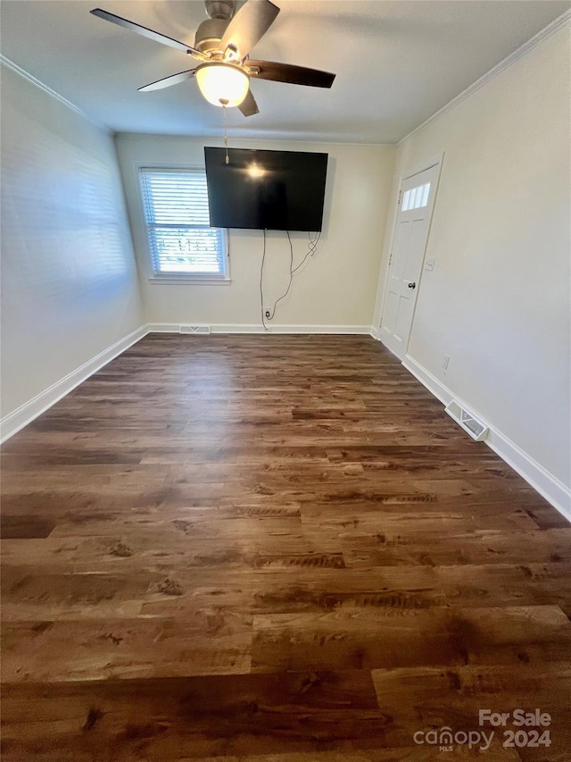 empty room featuring ceiling fan, dark hardwood / wood-style flooring, and ornamental molding