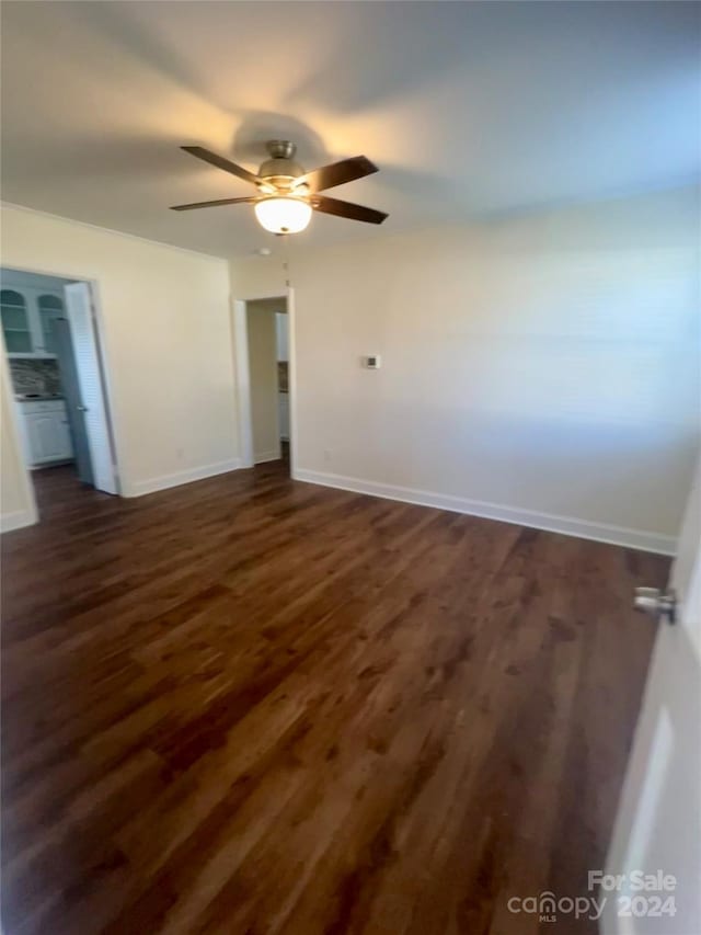 spare room with ceiling fan and dark hardwood / wood-style flooring