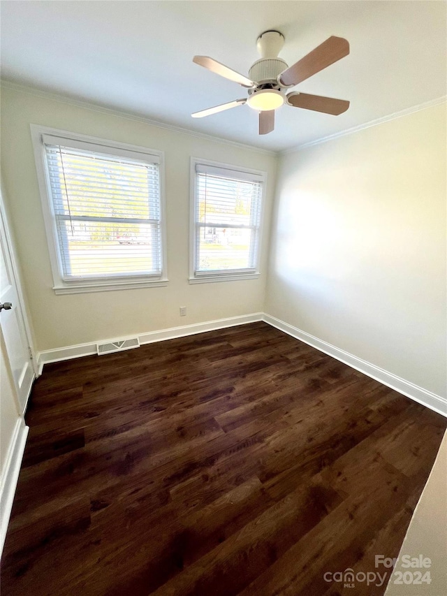 empty room featuring dark hardwood / wood-style floors, ceiling fan, and crown molding