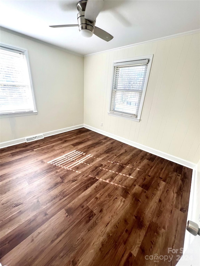 spare room with ceiling fan, plenty of natural light, dark hardwood / wood-style floors, and ornamental molding