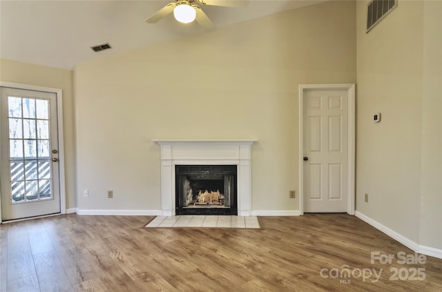 unfurnished living room with ceiling fan, high vaulted ceiling, and light hardwood / wood-style flooring