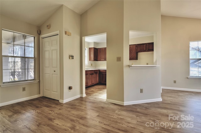 unfurnished room featuring hardwood / wood-style flooring and vaulted ceiling