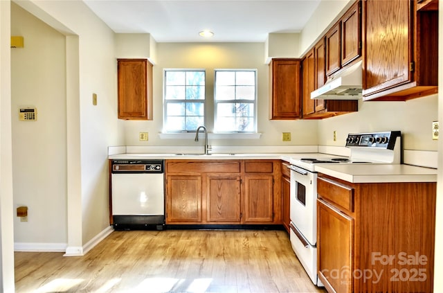 kitchen with sink, white appliances, and light hardwood / wood-style floors